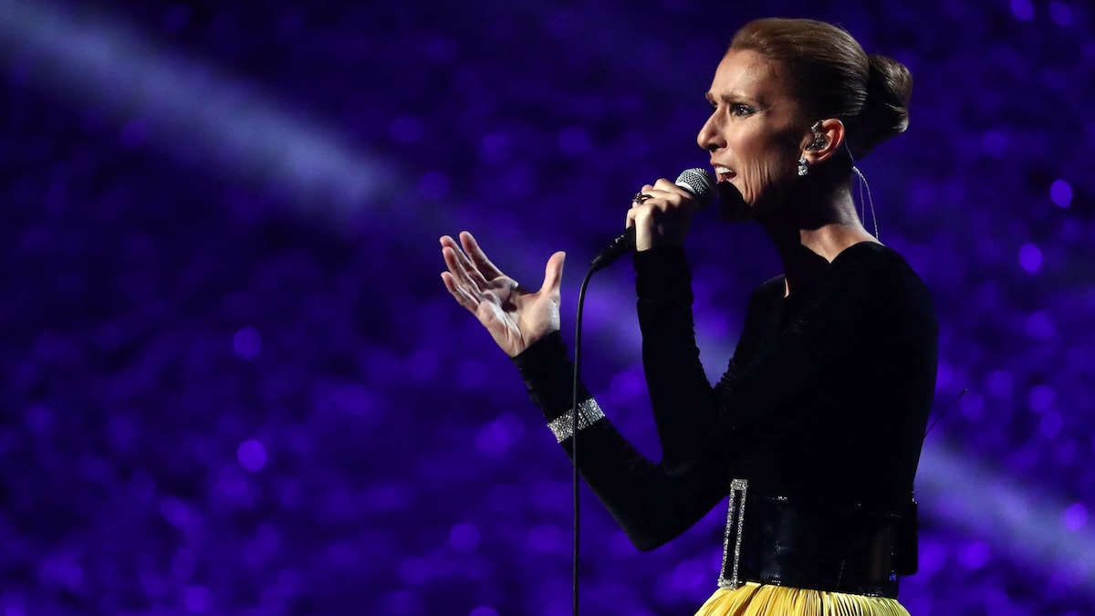 Céline Dion, micro à la main, chante sur scène.