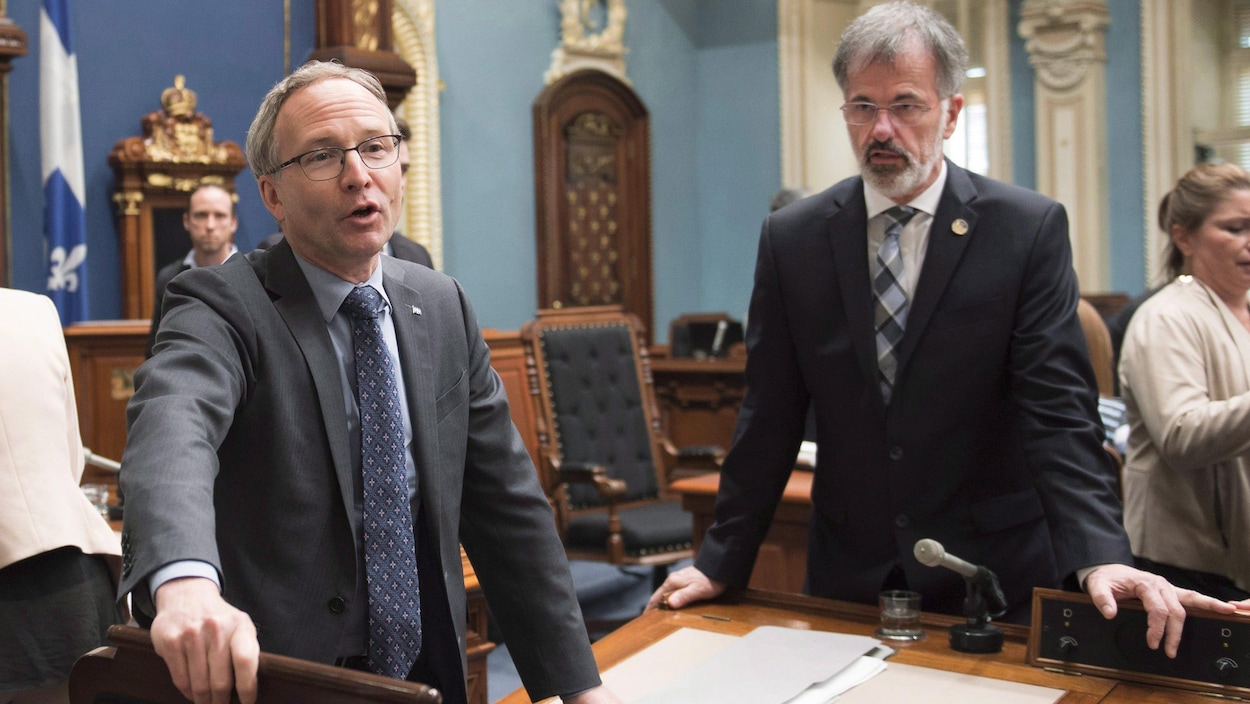 Martin Coiteux et Guy Ouellette discutent à l'Assemblée nationale.