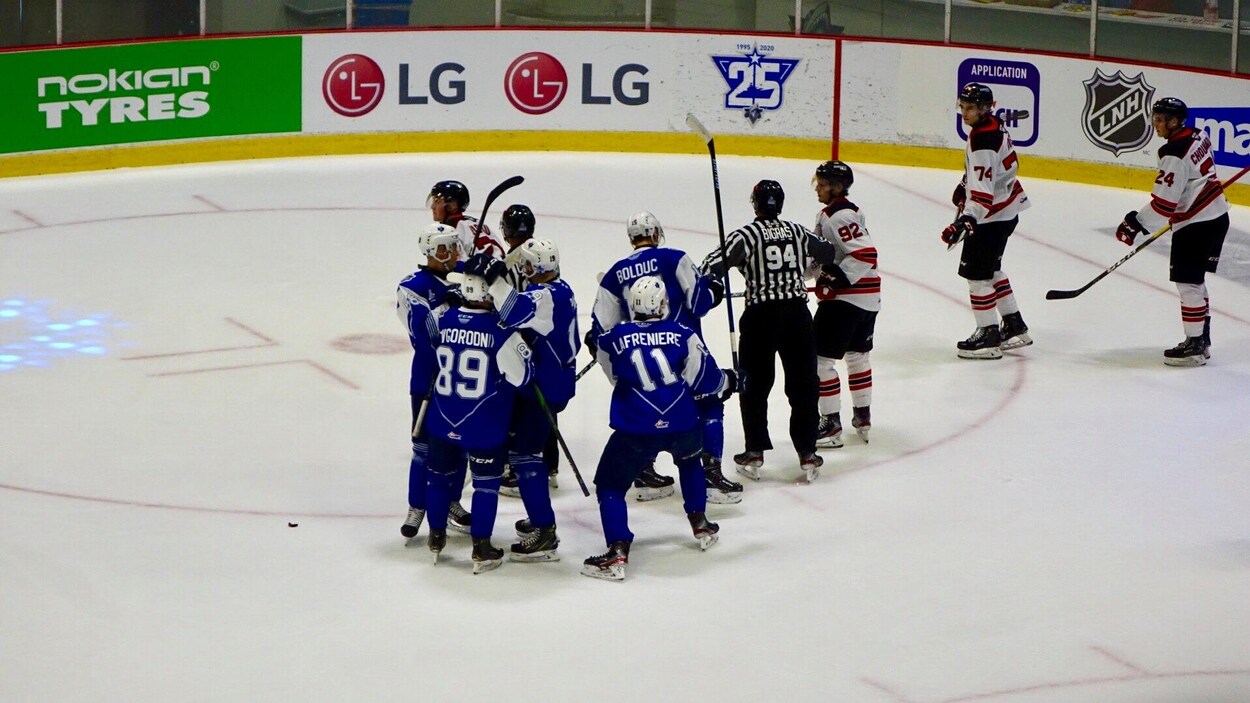Les joueurs de l'Océanic se félicitent sur la glace après avoir marqué un but.