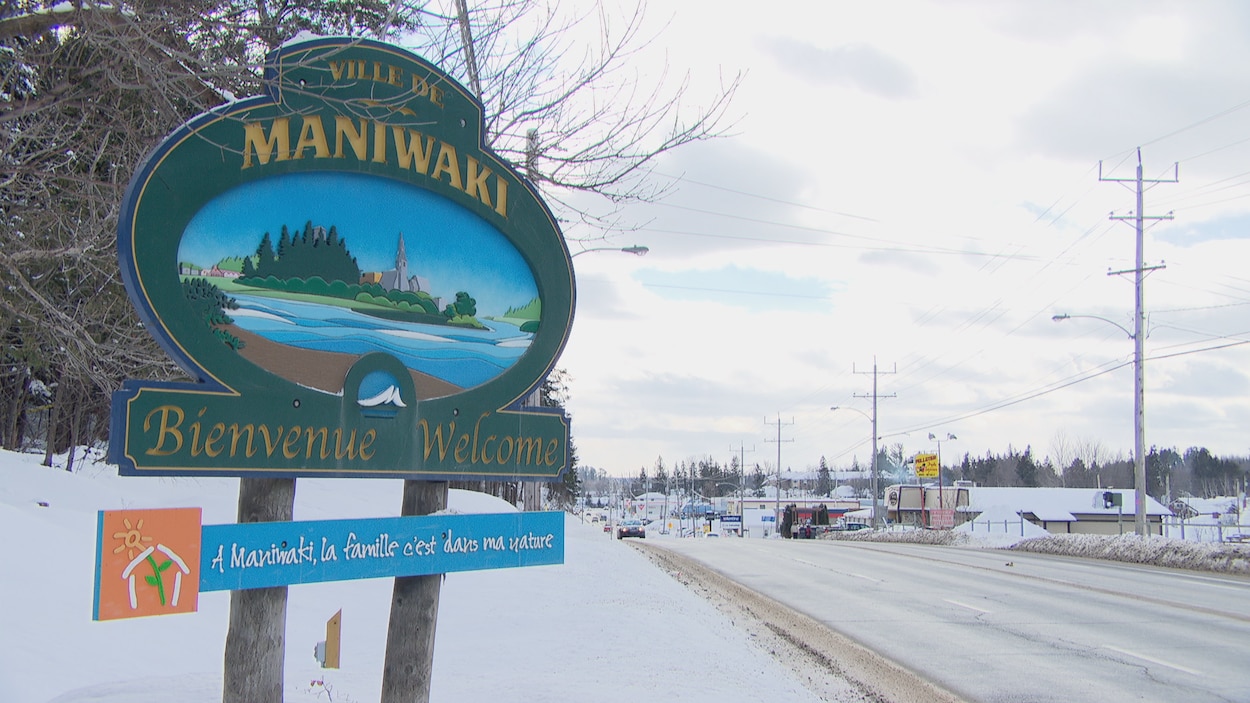 Une grande pancarte aux abords d'un boulevard sur laquelle on peut lire « Ville de Maniwaki, bienvenue. À Maniwaki, la famille c'est dans ma nature ».