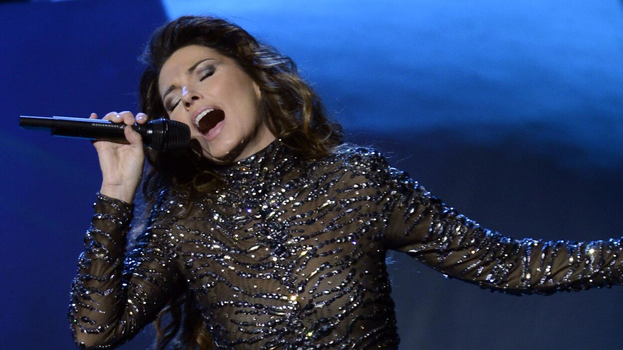 La chanteuse Shania Twain chante avec un micro à la main.