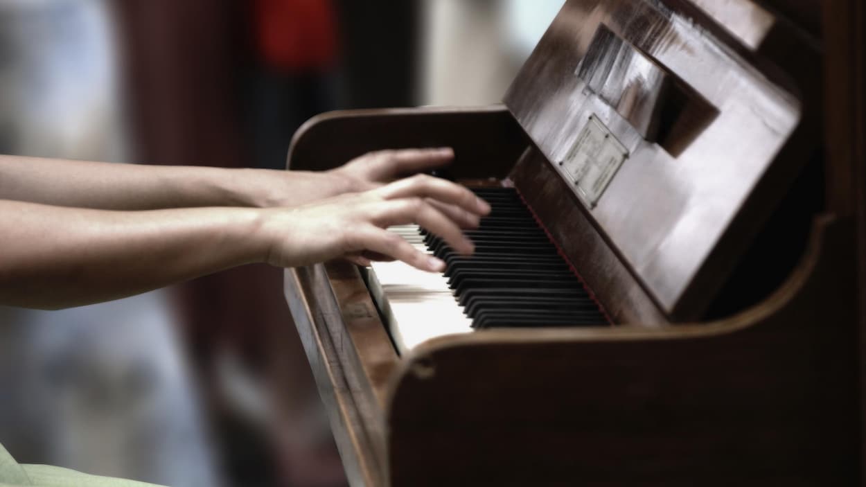 Des mains sur un piano.