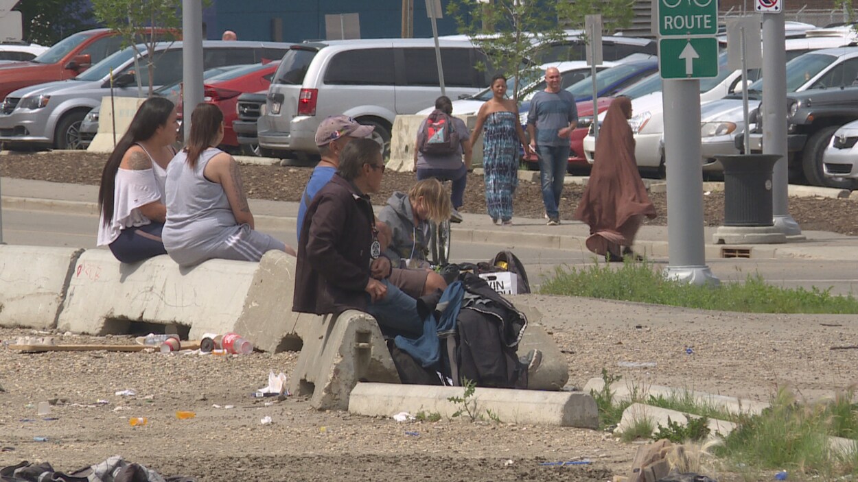 Des personnes dans le besoin assises sur des garde-fous de béton près du centre-ville d'Edmonton.