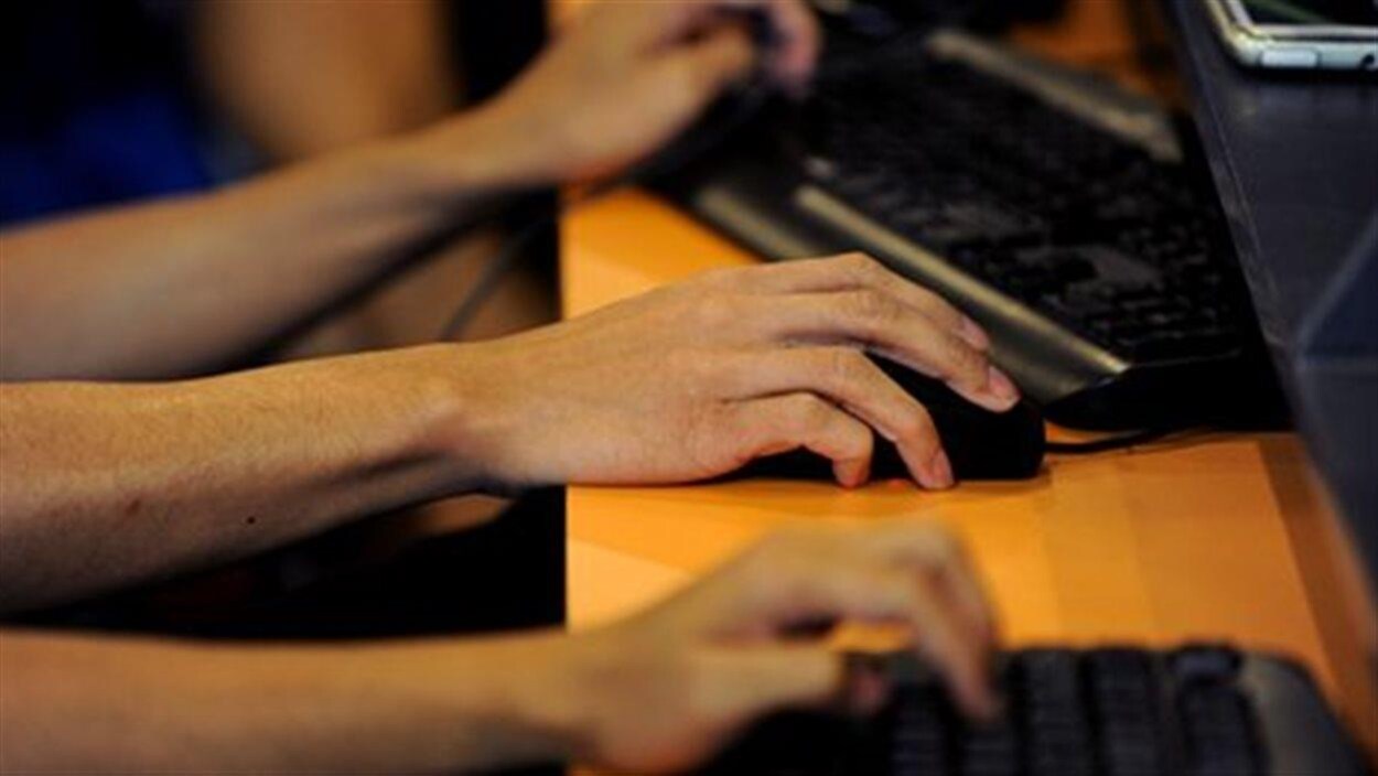Des mains sur des claviers et une souris d'ordinateur