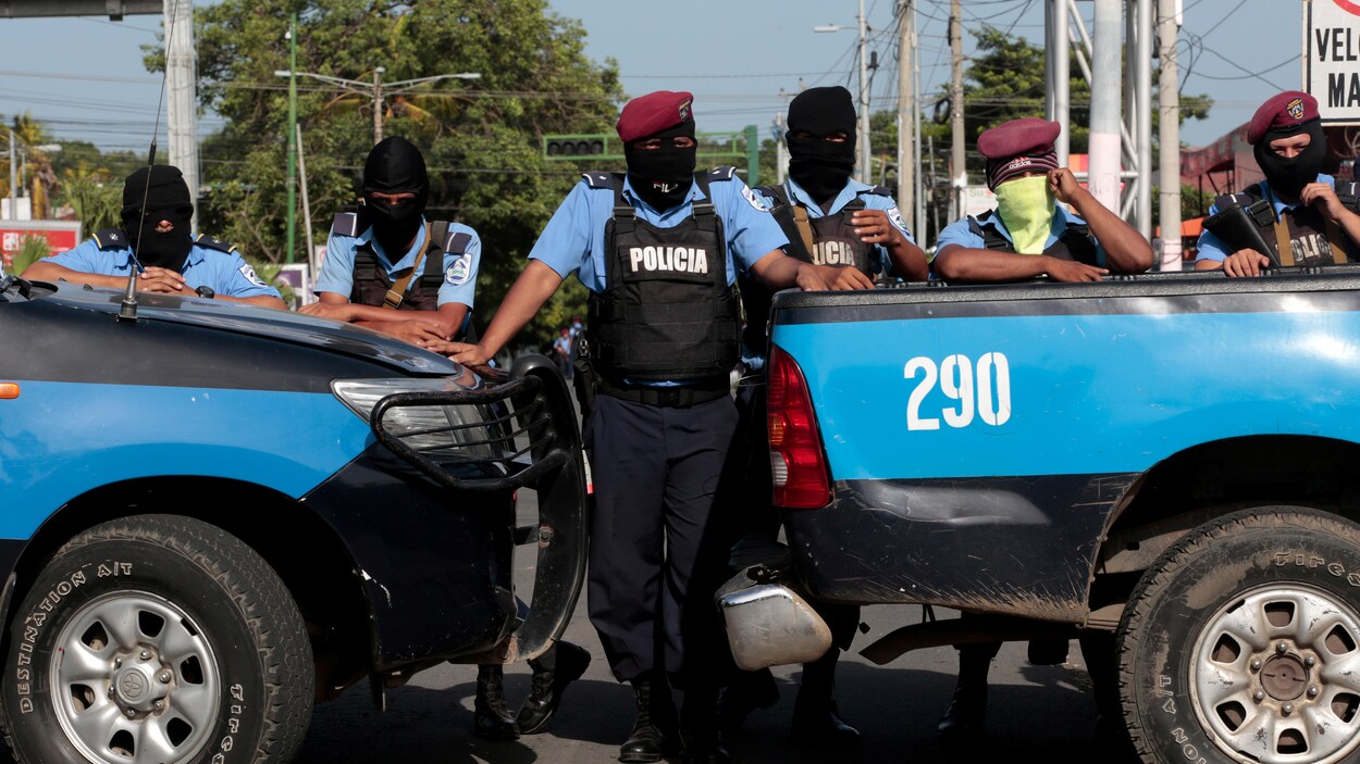 Six policiers encagoulés et alignés bloquent le passage avec leurs véhicules. Six policiers encagoulés et alignés bloquent le passage avec leurs véhicules.