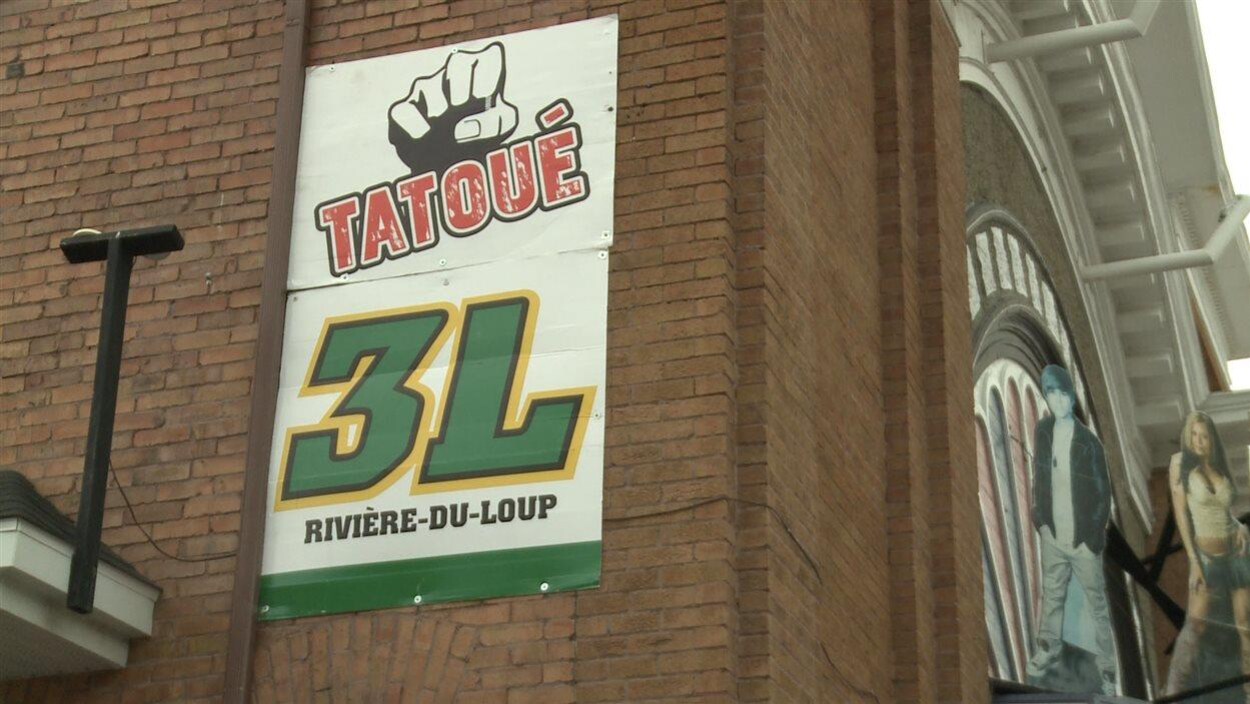 Une affiche des 3L sur une façade.