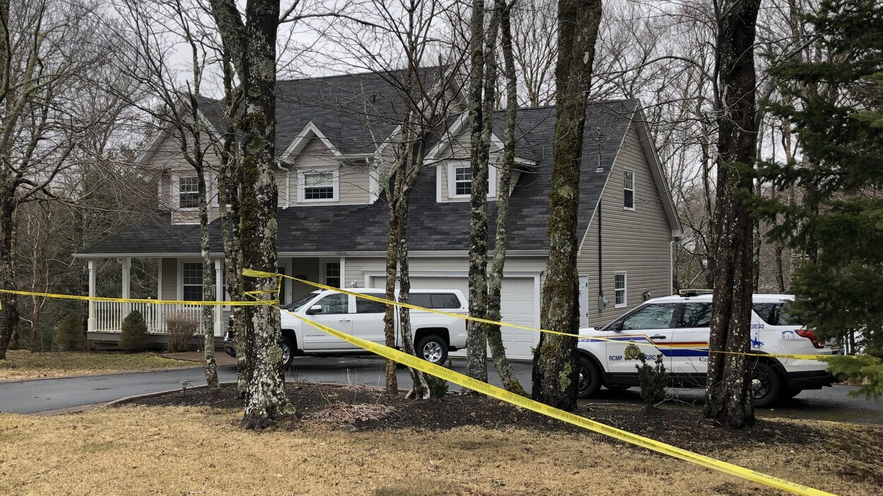 Des véhicules de la GRC sont stationnés dans l'entrée d'une maison, une scène de crime.