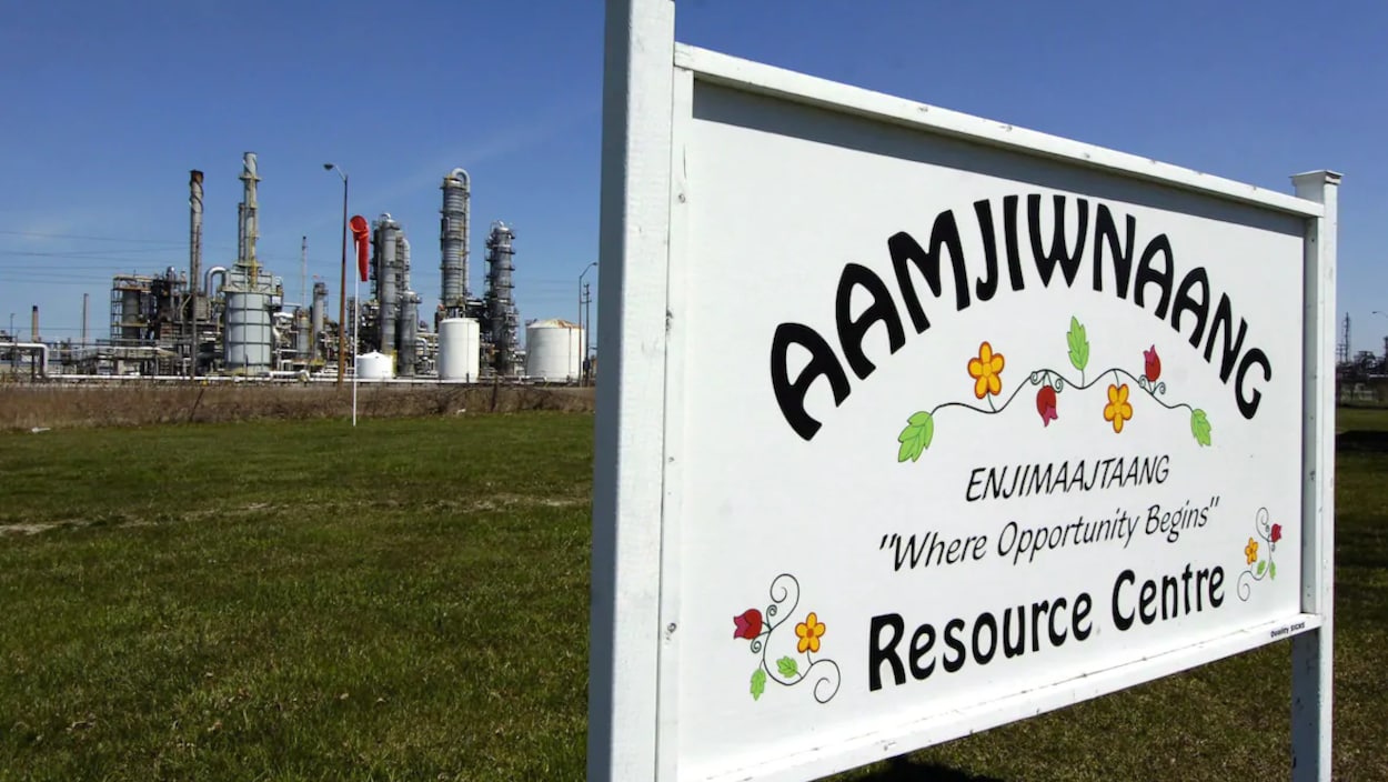 Une pancarte du centre de ressources d'Aamjiwnaang près d'une usine.