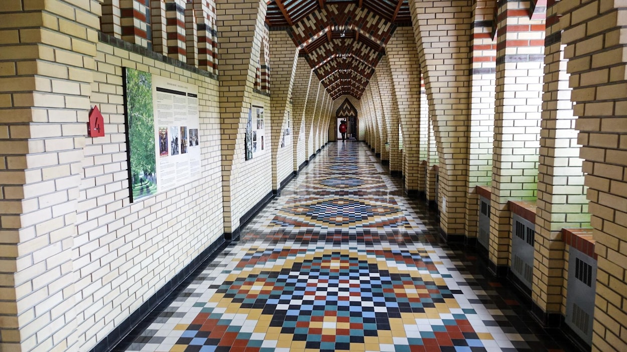 Un cameraman au bout d'un long corridor à l'Abbaye de Sainte-Benoit-du-Lac