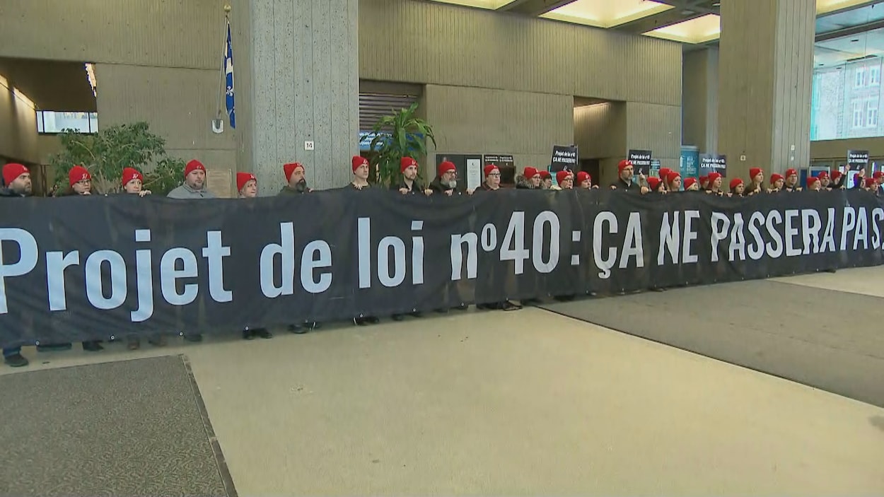 Des manifestants avec une banderole : « Projet de loi numéro 40 : ça ne passera pas » dans les bureaux du ministère de l'Éducation à Québec