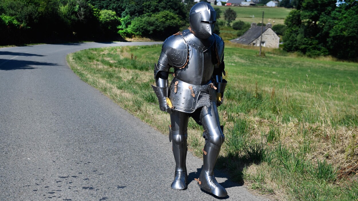 L'artiste Abraham Poincheval marche le long d'une route en Bretagne, vêtu d'une armure. L'artiste Abraham Poincheval marche le long d'une route en Bretagne, vêtu d'une armure.