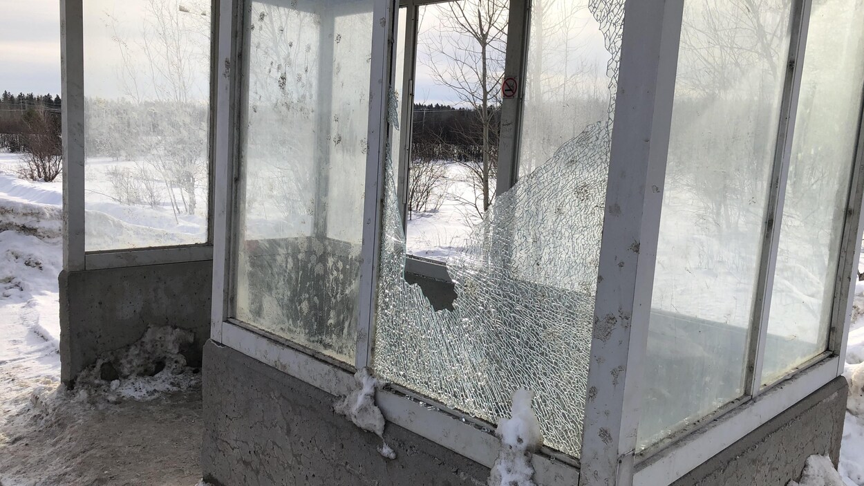 Un abribus avec une vitre fracassée.