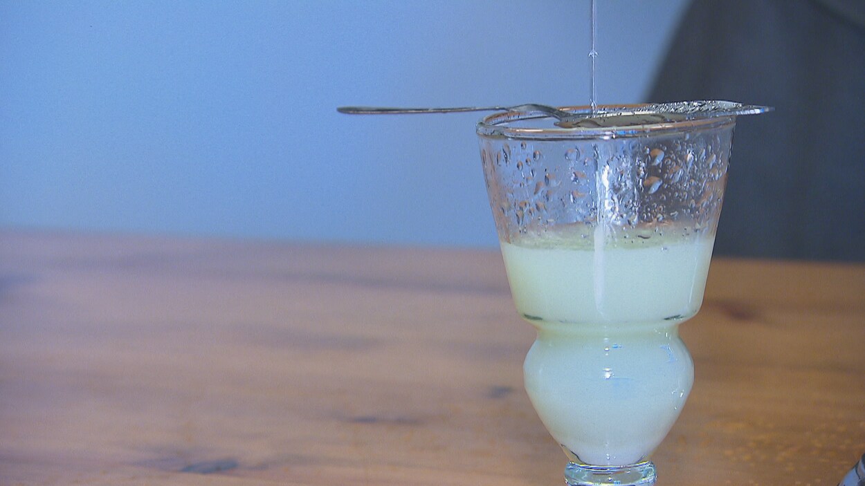 L'eau glacée s'écoule sur un cube de sucre pour diluer l'absinthe dans le verre. L'eau glacée s'écoule sur un cube de sucre pour diluer l'absinthe dans le verre.