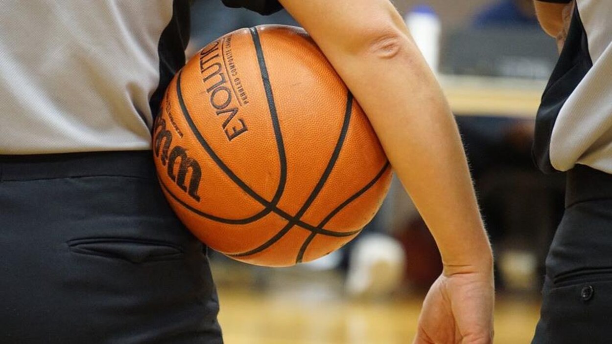 Un garçon qui tient un ballon de basketball.