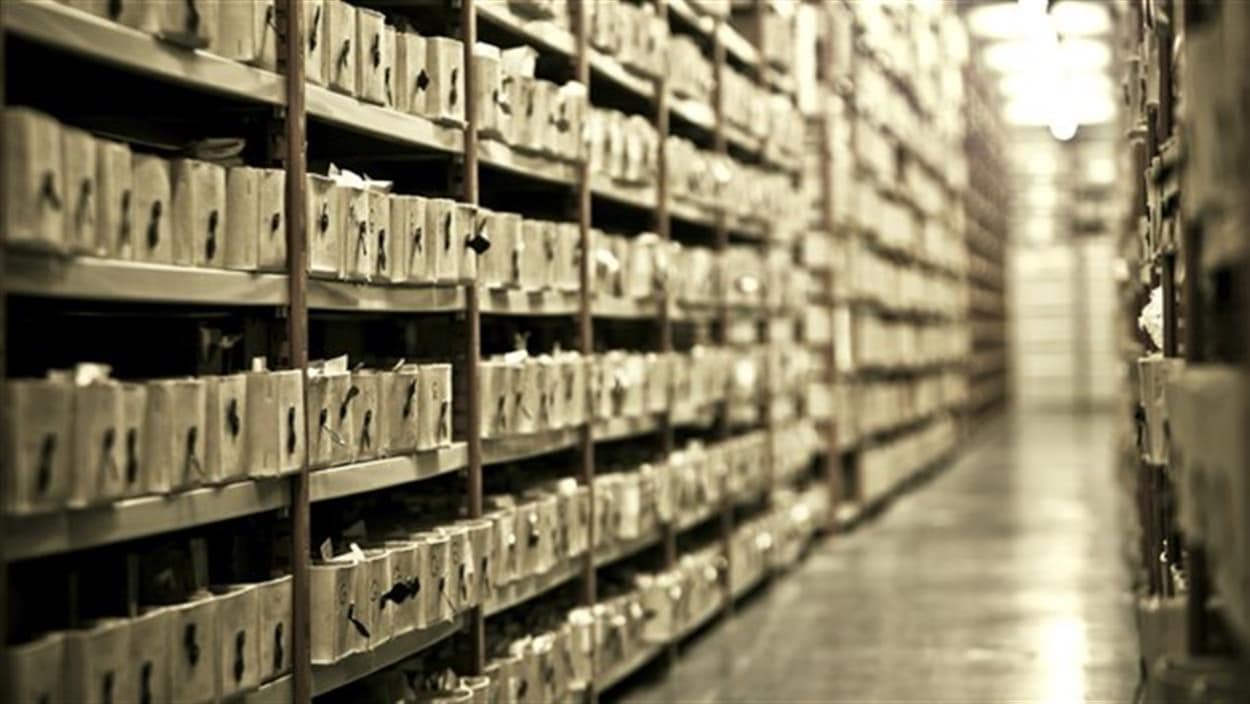 Des étagères remplies de caisses de documents dans un centre d’archives