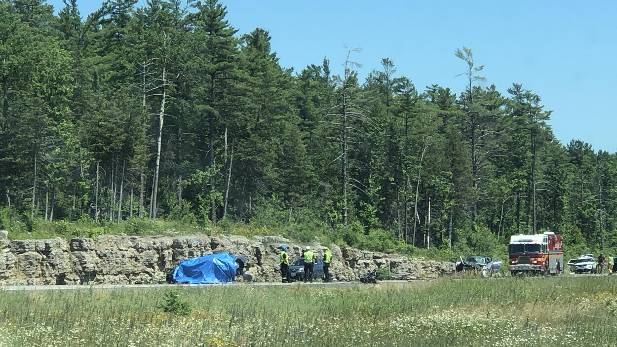 De premiers répondants près d'un véhicule renversé, d'une voiture endommagée et d'un camion de pompier sur l'autoroute 417.