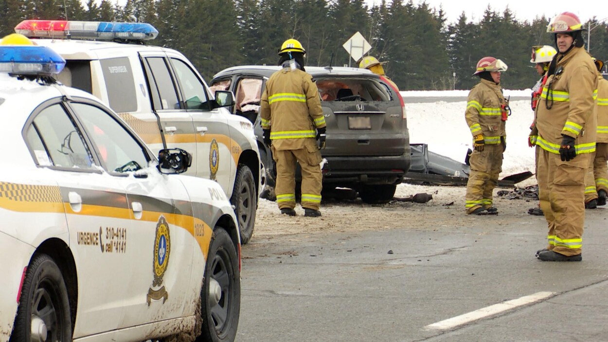Voiture de police et pompiers près d'une voiture accidentée.