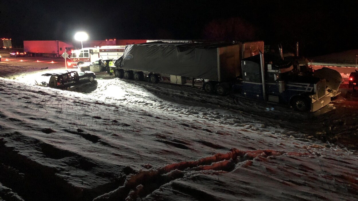 Un semi-remorque, une voiture accidentée et un camion de pompier.