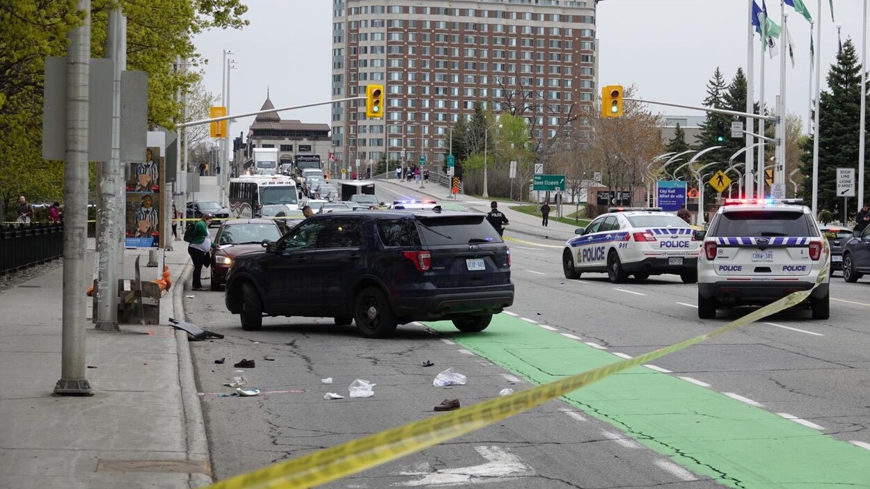 Des véhicules de police bloquent la rue à la circulation.