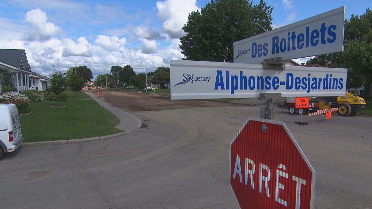 Une pancarte d'arrêt et deux pancartes avec des noms de rues.