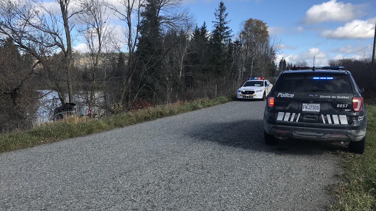 La voiture accidentée est dans le fossé. Deux voitures de la Sûreté du Québec sont stationnées sur le chemin où a eu lieu l'accident.