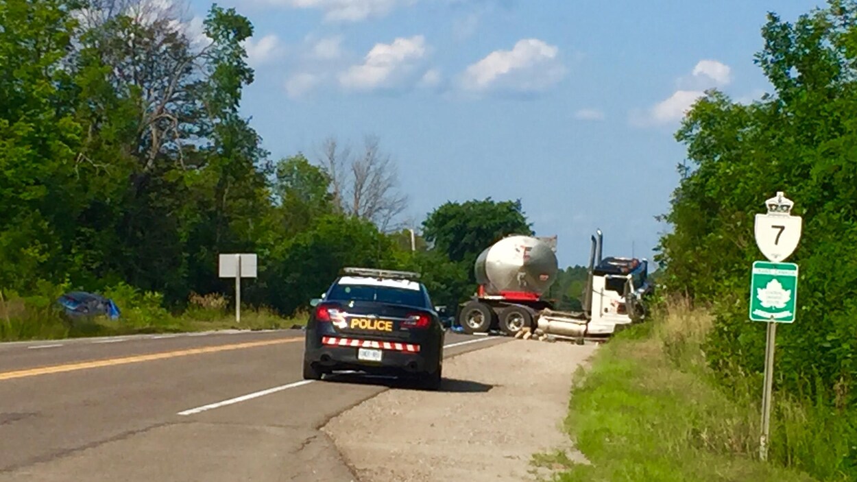 Une voiture de police et un camion accidenté.