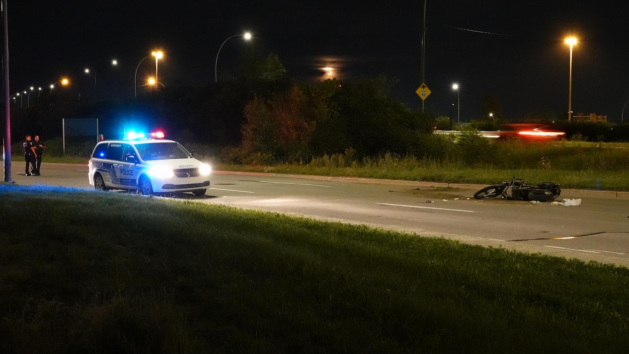 Une moto accidentée et une auto-patrouille.
