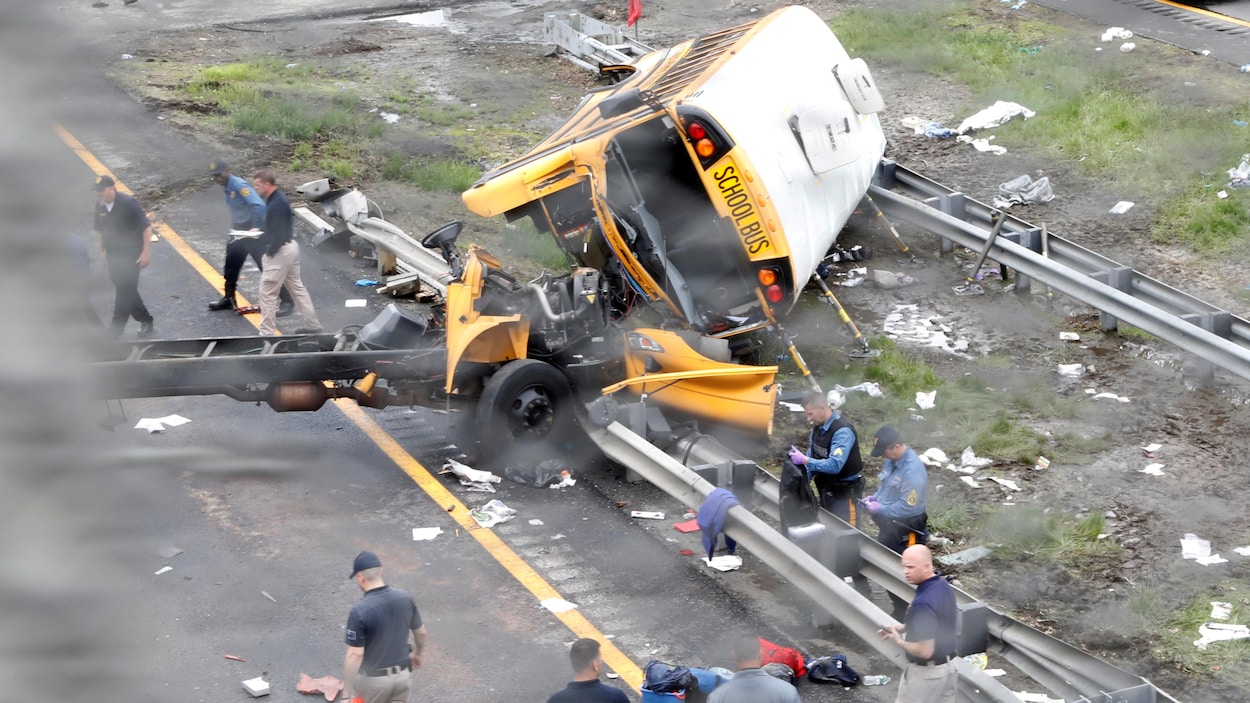 Un autobus scolaire est couché sur le côté et lourdement abîmé. Un autobus scolaire est couché sur le côté et lourdement abîmé.