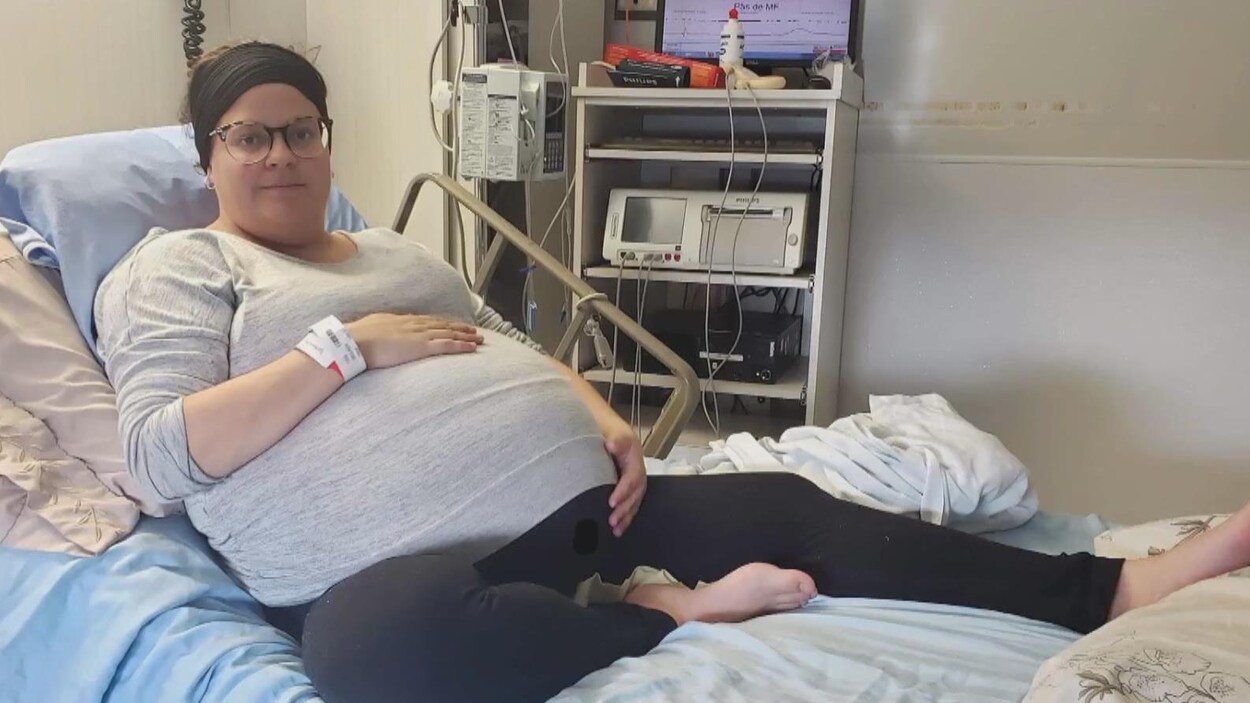 Une femme enceinte couchée sur un lit.