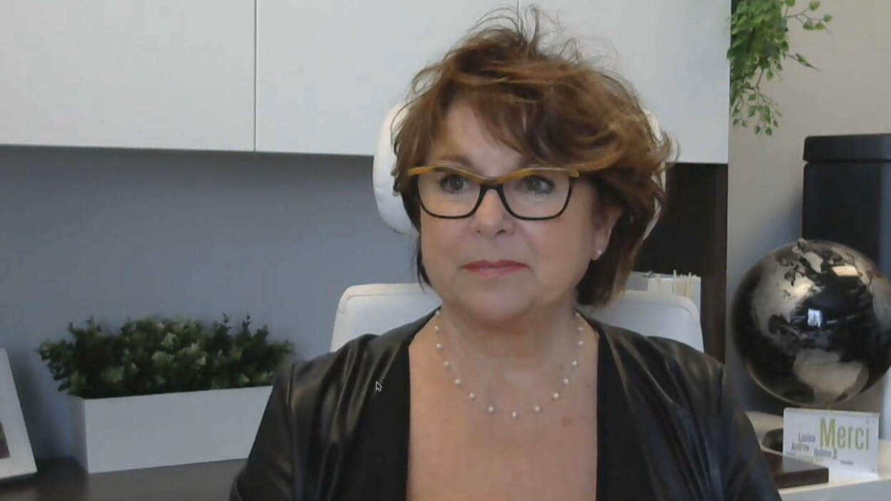 Monique Dansereau est assise à son bureau, des armoires et des plantes figurent derrière elle.