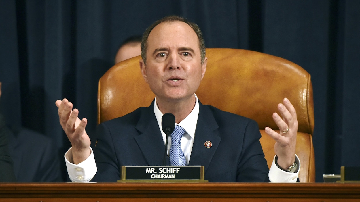 Adam Schiff, présidant une audience publique, regarde droit devant lui, les mains levées.
