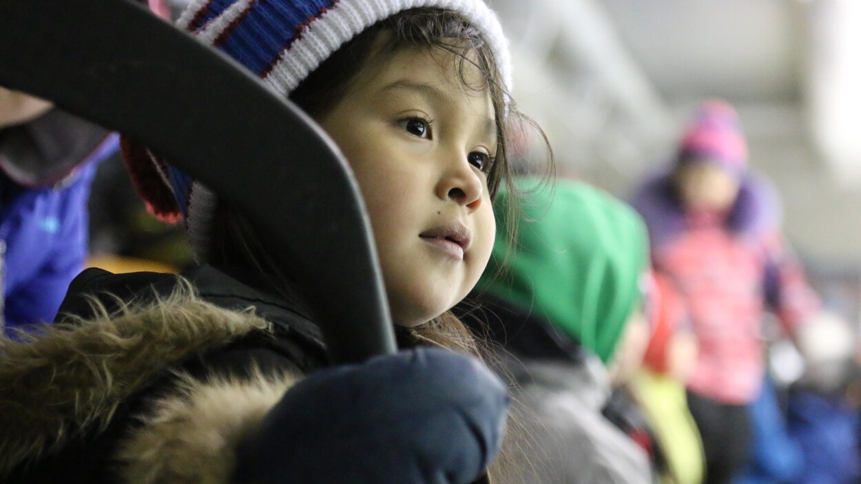 Fillette inuit dans l'assistance d'un match de hockey, à Salluit, Nunavik.