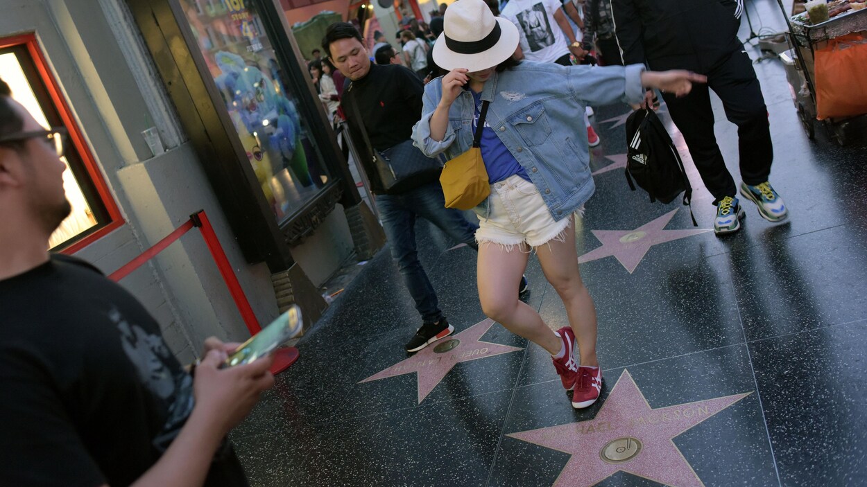 Une femme fait un geste semblable au chanteur.