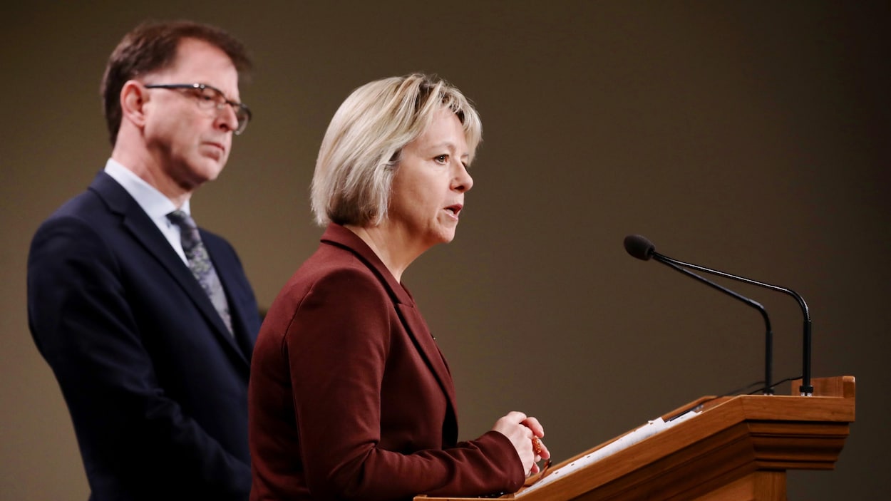 Le ministre de la Santé, Adrian Dix, et la médecin hygiéniste en chef de la province, Bonnie Henry, devant un lutrin.