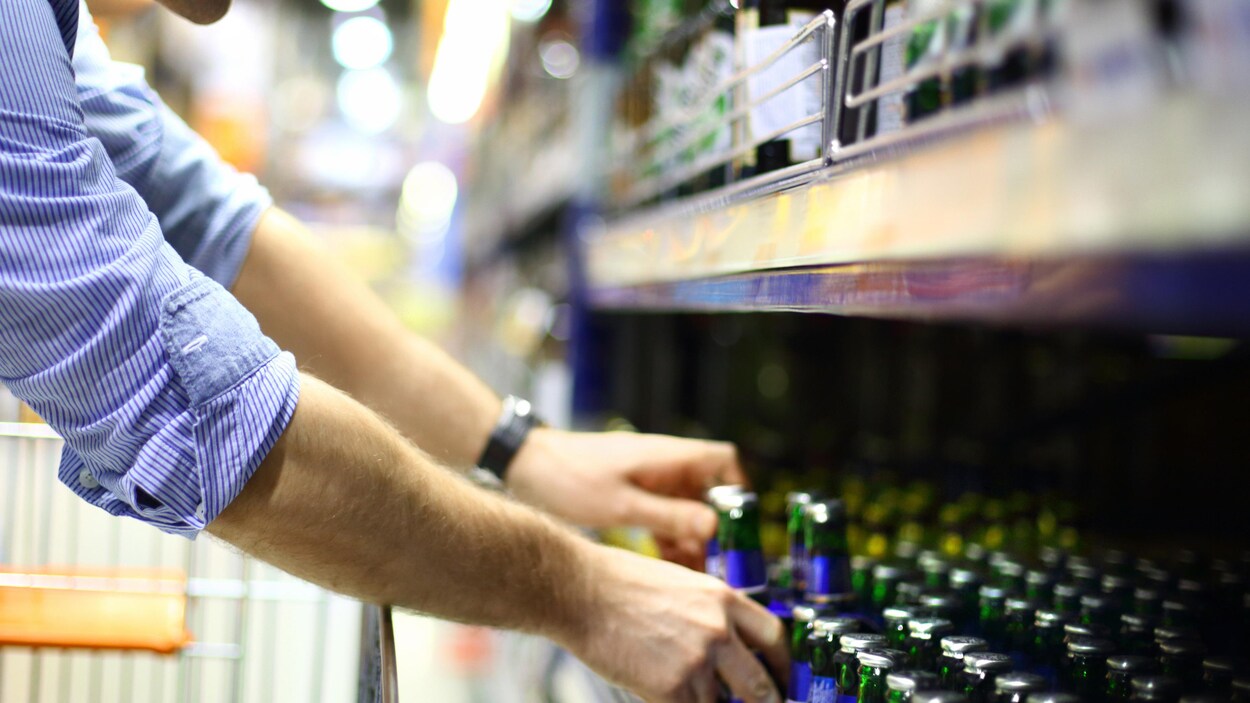 Un homme dans un supermarché achetant de la bière.