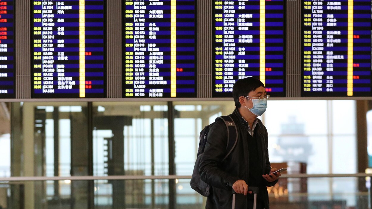 Un homme portant un masque avec un tableau lumineux en arrière plan