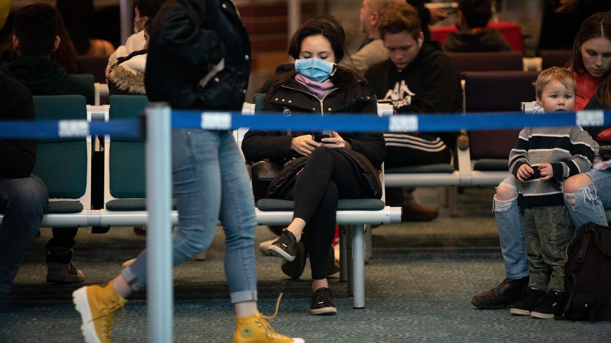 Une passagère à l'aéroport de Vancouver YVR porte un masque.