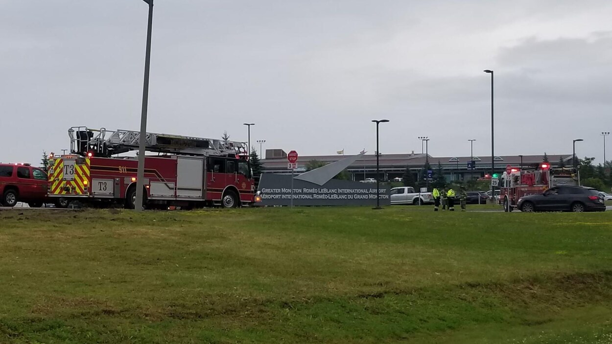 Camion de pompiers et policiers à l'entrée de l'aéroport de Moncton.
