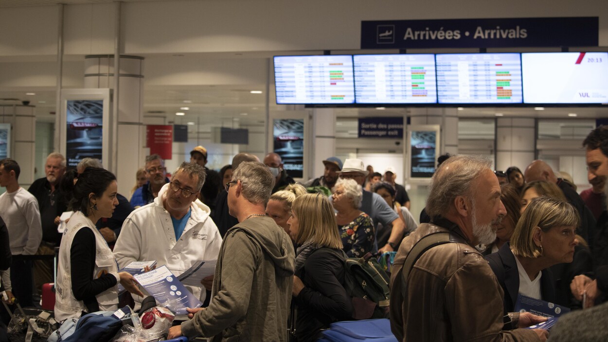 Des gens font la file à l'aéroport de Montréal.
