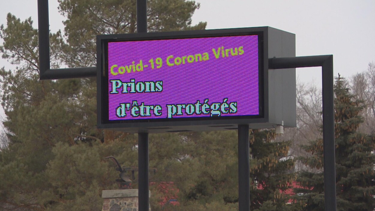 Une enseigne électronique sur lequel il est écrit : COVID-19 coronavirus Prions d'être protégés.