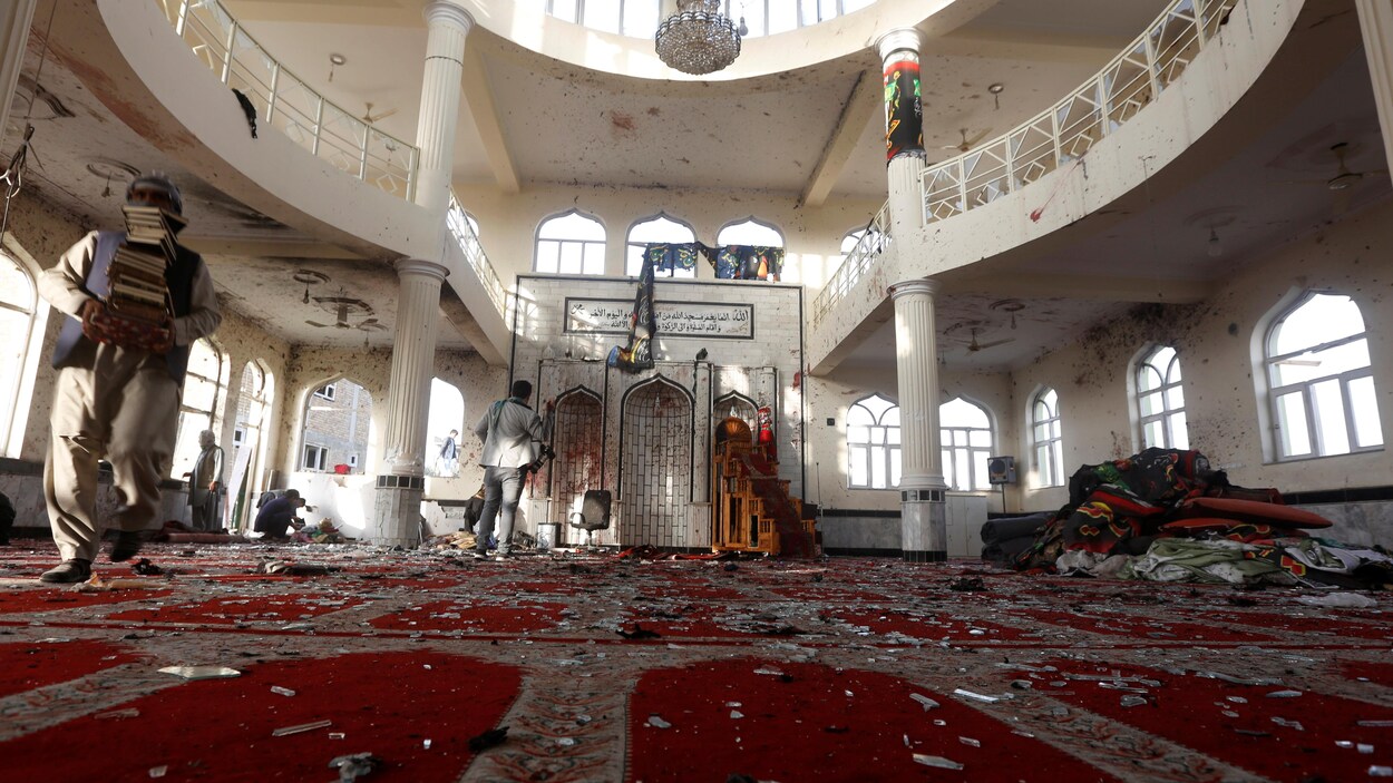 Un homme déplace des livres pendant que d'autres inspectent les dégâts causés par un kamikaze dans une mosquée de Kaboul en Afghanistan. Un homme déplace des livres pendant que d'autres inspectent les dégâts causés par un kamikaze dans une mosquée de Kaboul en Afghanistan.