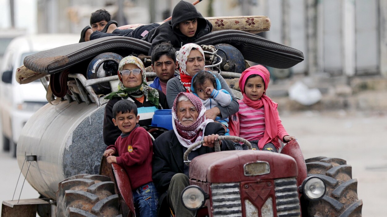 Une famille de neuf personnes part en tracteur avec ses possessions. Une famille de neuf personnes part en tracteur avec ses possessions.