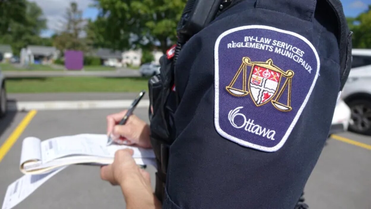 Une agente rédige une contravention.