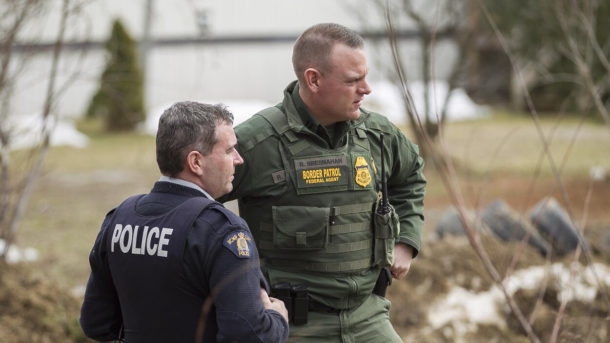 Un agent de la GRC discute avec un agent des services frontaliers américains près d'Hemmingford, au Québec.
