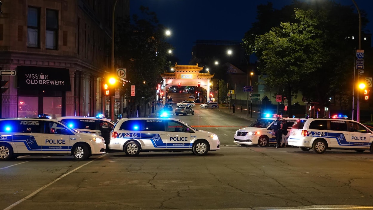 Des voitures de police barrent une rue dans la nuit. La pagode illuminée nous montre que nous sommes sur le boulevard Saint-Laurent Des voitures de police barrent une rue dans la nuit. La pagode illuminée nous montre que nous sommes sur le boulevard Saint-Laurent