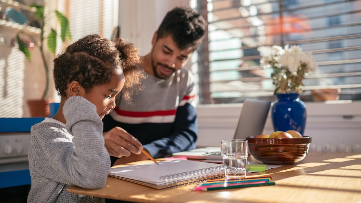 Un père aide sa fille avec ses devoirs