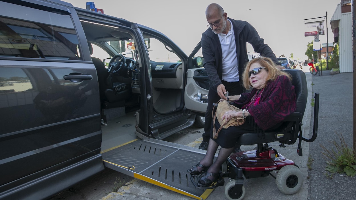 Mme Gladu sort d'un véhicule adapté pour handicapés.