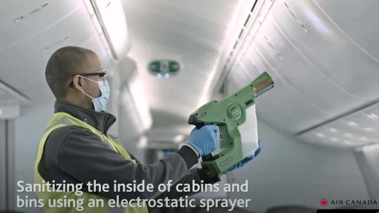 Un travailleur désinfecte la cabine d'un avion.