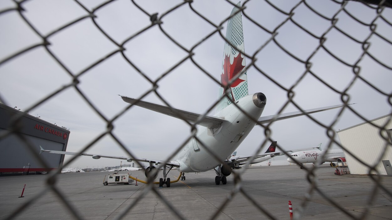 Vue d'un avion d'Air Canada a travers une barrière.