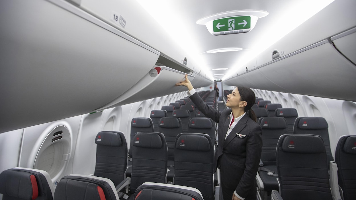 Une hôtesse de l'air à l'intérieur d'un avion A220 d'Airbus lors d'une présentation à la presse.